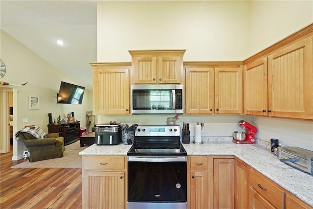 76 Red Gate Rd, Waynesville, GA 31566 - kitchen featuring appliances with stainless steel finishes, vaulted ceiling, light brown cabinets, light wood-style flooring, and light stone countertops