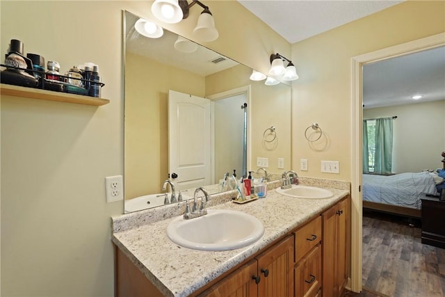 76 Red Gate Rd, Waynesville, GA 31566 - bathroom featuring double vanity, connected bathroom, and wood finished floors