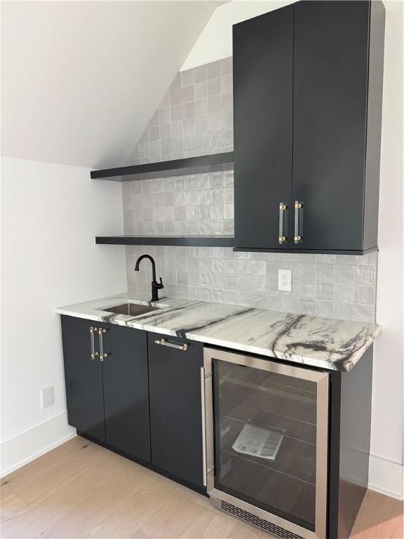 104 Point Ln, Saint Simons Island, GA 31522 - indoor wet bar with wine cooler, lofted ceiling, light wood finished floors, tasteful backsplash, and baseboards