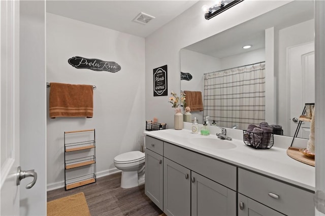 bathroom featuring wood-type flooring, vanity, and toilet