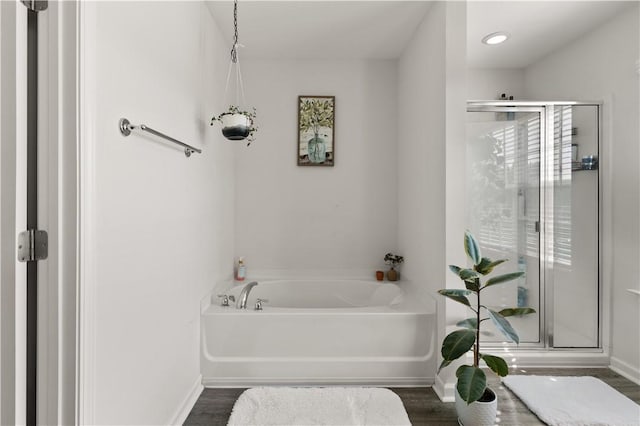 bathroom featuring shower with separate bathtub and hardwood / wood-style flooring