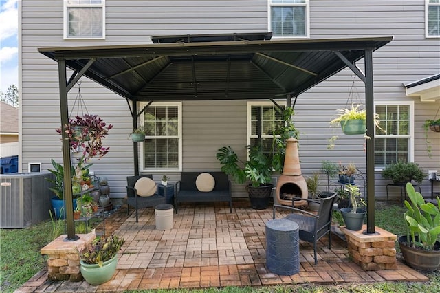 view of patio / terrace with central AC unit, a gazebo, and an outdoor fireplace