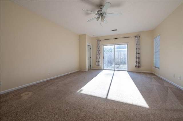 unfurnished room featuring ceiling fan, light colored carpet, and a textured ceiling