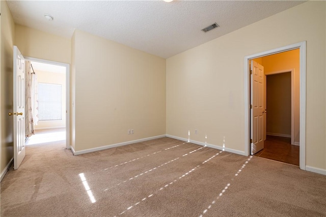 carpeted spare room with a textured ceiling