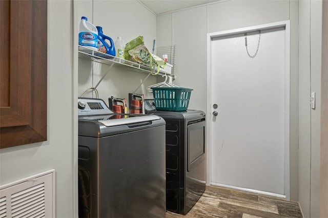 laundry room with washer and clothes dryer and hardwood / wood-style floors