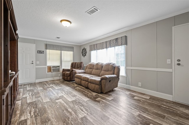 living room featuring light hardwood / wood-style floors, a textured ceiling, and ornamental molding