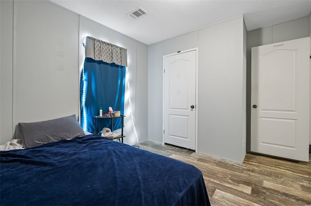 bedroom featuring hardwood / wood-style flooring and a textured ceiling