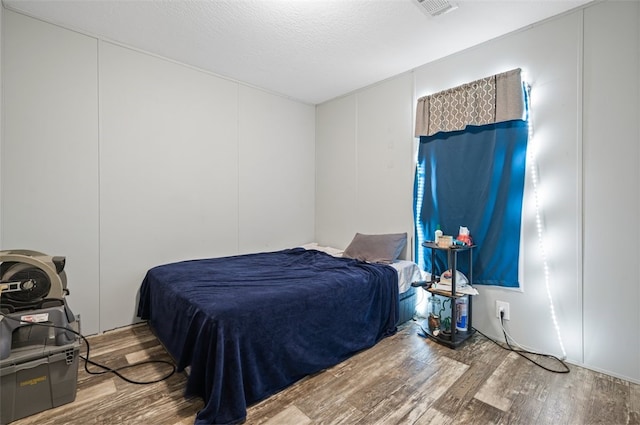 bedroom with wood-type flooring and a textured ceiling