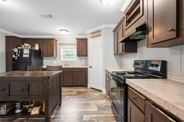 kitchen featuring black appliances, crown molding, light hardwood / wood-style flooring, custom range hood, and dark brown cabinetry