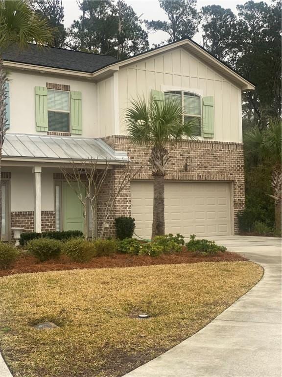 801 Mariners Cir, Saint Simons Island, GA 31522 - view of front facade with brick siding, an attached garage, concrete driveway, board and batten siding, and a standing seam roof