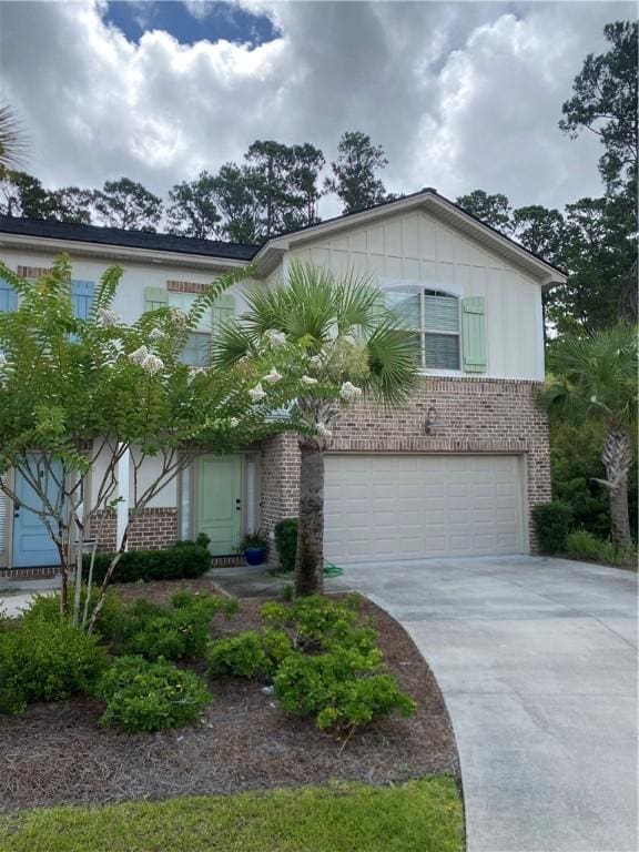 801 Mariners Cir, Saint Simons Island, GA 31522 - view of front of home featuring brick siding, a garage, concrete driveway, and board and batten siding
