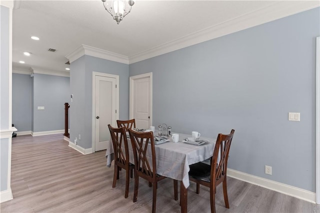 dining area with wood-type flooring and ornamental molding