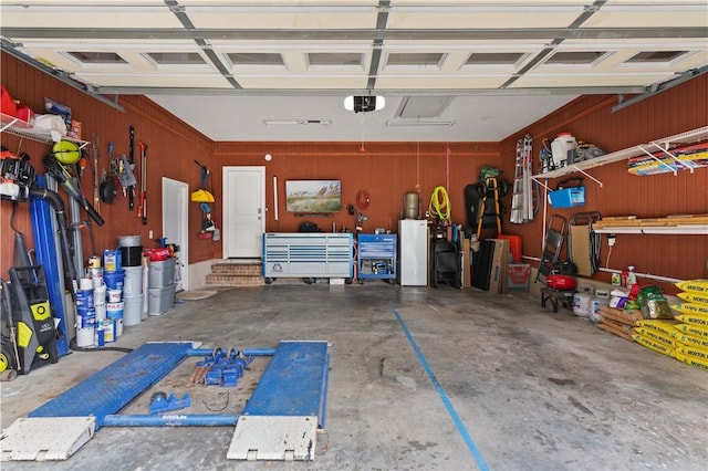 garage featuring wood walls and a garage door opener