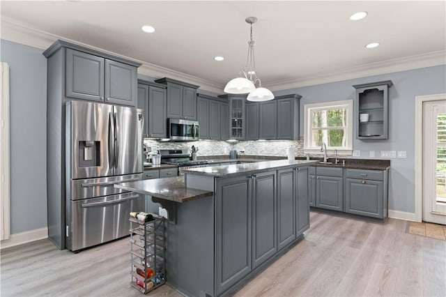 kitchen with pendant lighting, a center island, light hardwood / wood-style flooring, gray cabinets, and appliances with stainless steel finishes