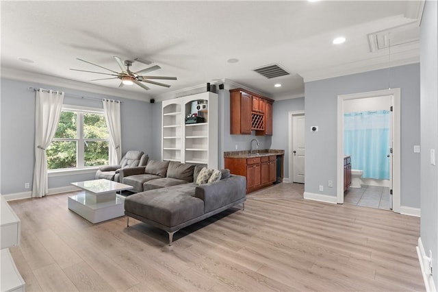 living room with light hardwood / wood-style flooring, ceiling fan, ornamental molding, and sink