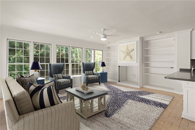 living room featuring ceiling fan, built in features, and ornamental molding