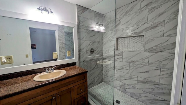 bathroom with a tile shower and vanity