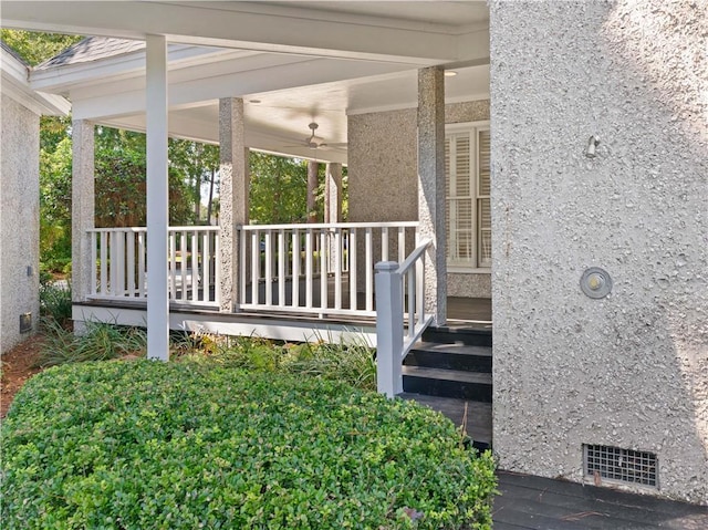 view of exterior entry with ceiling fan and covered porch