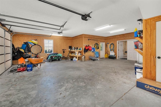 garage with a garage door opener and wood walls