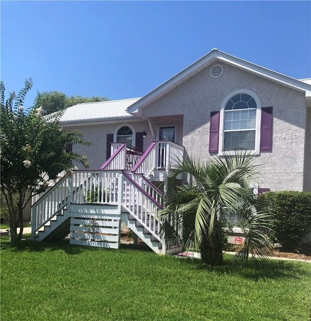 105 Thompson Cv, Saint Simons Island, GA 31522 - single story home featuring stairs, stucco siding, and a front lawn
