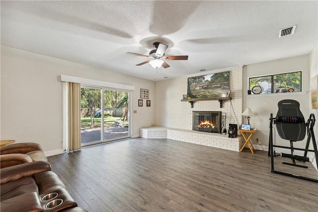 workout area with plenty of natural light, ceiling fan, dark hardwood / wood-style flooring, and a fireplace