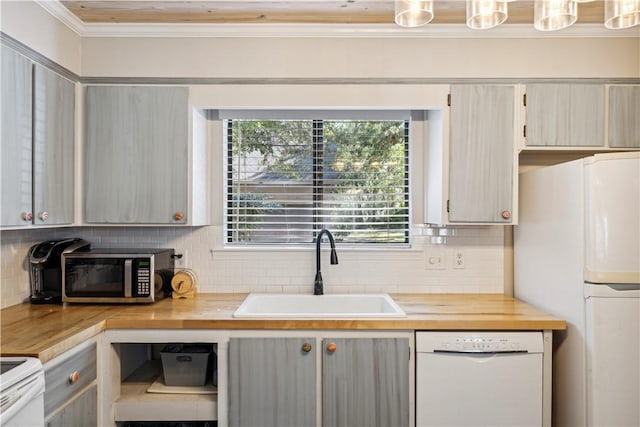 kitchen with tasteful backsplash, sink, pendant lighting, and white appliances