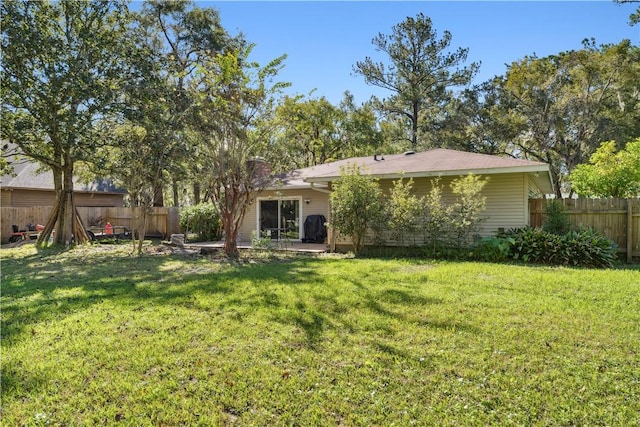 rear view of house with a yard and a patio