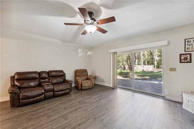 living room with ceiling fan, wood-type flooring, and a textured ceiling