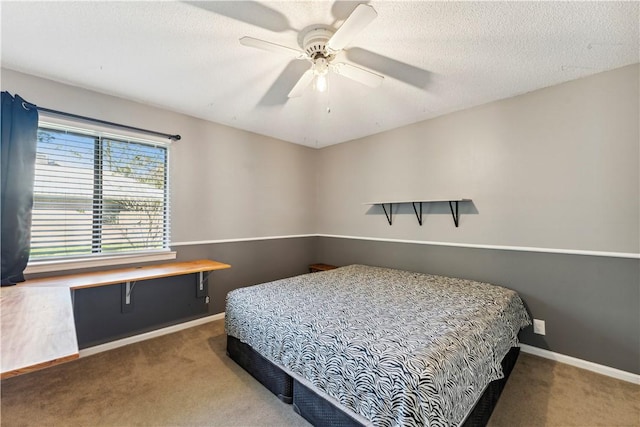 bedroom featuring ceiling fan, carpet floors, and a textured ceiling