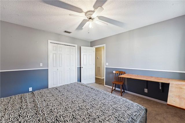 carpeted bedroom featuring a textured ceiling, a closet, and ceiling fan