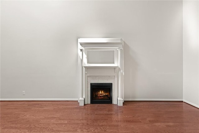 893 Wimbledon Dr, Saint Simons Island, GA 31522 - detailed view of a lit fireplace, wood finished floors, and baseboards