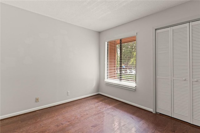 893 Wimbledon Dr, Saint Simons Island, GA 31522 - unfurnished bedroom with wood finished floors, baseboards, a textured ceiling, and a closet