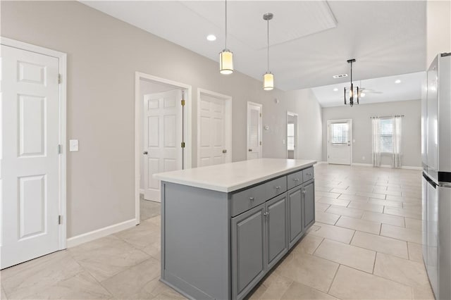 kitchen featuring a center island, pendant lighting, gray cabinetry, freestanding refrigerator, and open floor plan