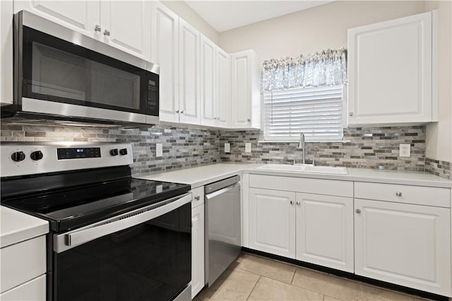 kitchen with appliances with stainless steel finishes, backsplash, a sink, and white cabinets