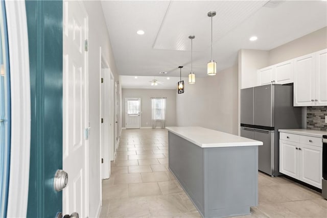 kitchen with tasteful backsplash, freestanding refrigerator, light countertops, and a kitchen island