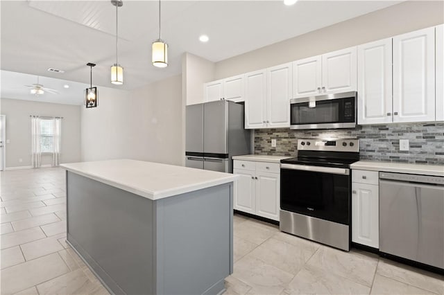 kitchen with tasteful backsplash, a center island, hanging light fixtures, stainless steel appliances, and white cabinetry