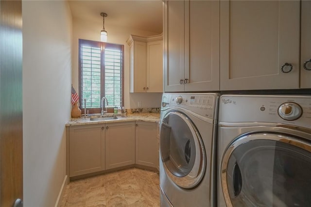 clothes washing area with cabinets, sink, and washing machine and clothes dryer