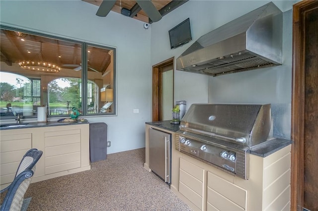 kitchen featuring light carpet, wall chimney exhaust hood, sink, beamed ceiling, and stainless steel refrigerator