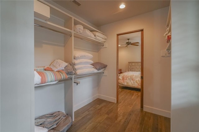 spacious closet with hardwood / wood-style floors and ceiling fan