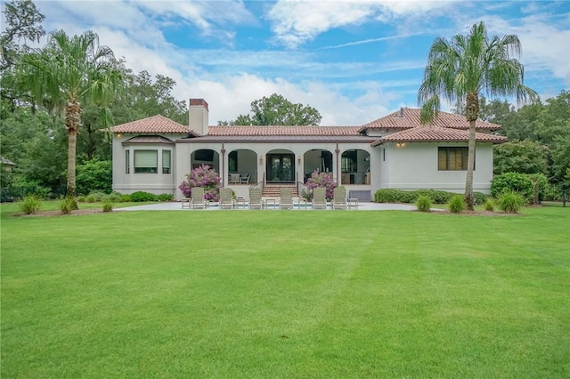 rear view of property featuring a yard and a porch