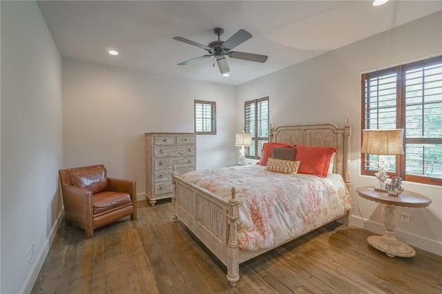 bedroom featuring dark hardwood / wood-style floors, multiple windows, and ceiling fan