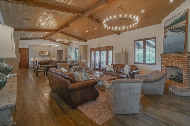 living room with a brick fireplace, wood ceiling, dark wood-type flooring, a notable chandelier, and beamed ceiling