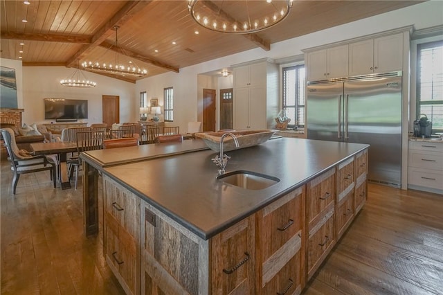 kitchen featuring a large island, sink, vaulted ceiling with beams, dark hardwood / wood-style flooring, and stainless steel built in refrigerator