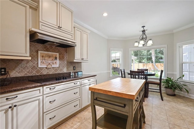 100 Southern Oaks Ln, Saint Simons Island, GA 31522 - kitchen featuring cream cabinets, wood counters, black electric cooktop, a chandelier, and tasteful backsplash