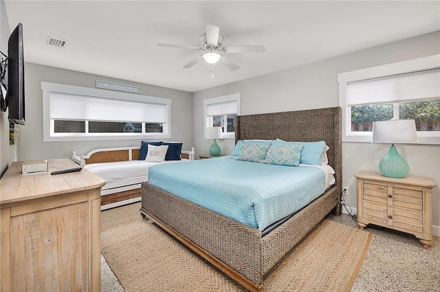 bedroom featuring baseboards, visible vents, light speckled floor, and a ceiling fan