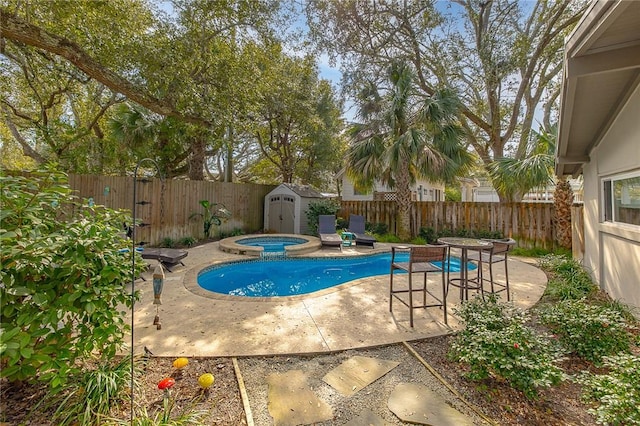 view of swimming pool with a patio area, a fenced backyard, a storage shed, and an in ground hot tub