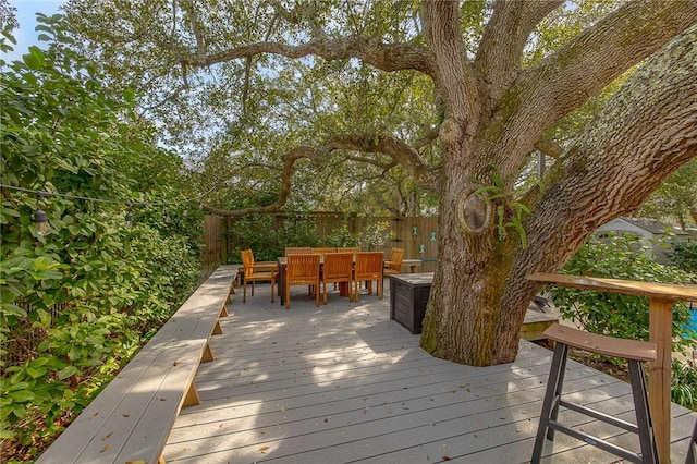 wooden terrace featuring outdoor dining space and fence