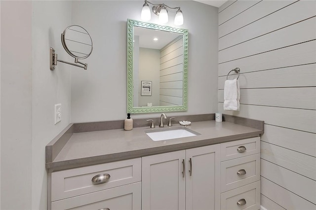 bathroom featuring vanity and wooden walls