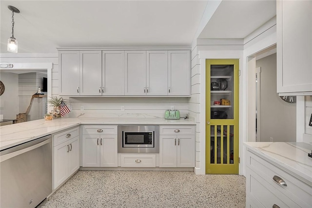 kitchen with light speckled floor, stainless steel appliances, light stone counters, and decorative light fixtures