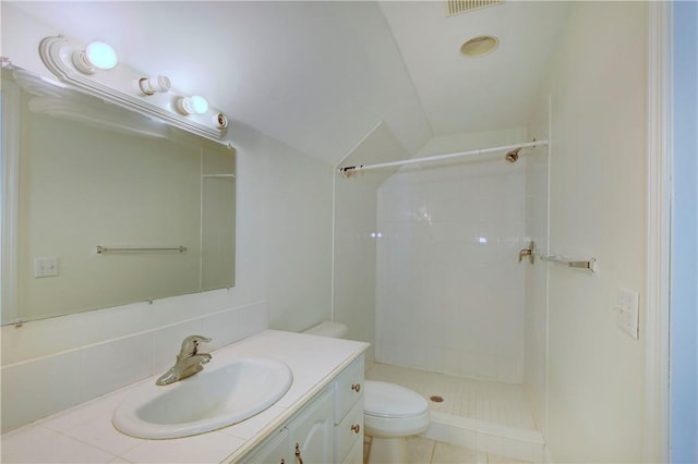 bathroom with tile patterned flooring, a shower, lofted ceiling, toilet, and vanity